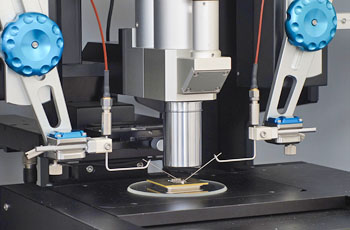  Precision probes positioned under microscope observation for localized electrical inspection of a micro-scale sample
